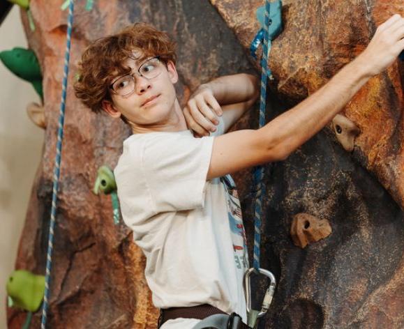 a student climbing the rock wall in baun fitness center